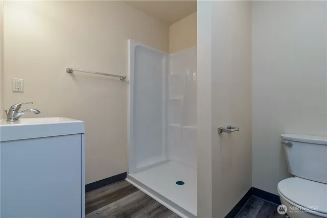 a bathroom with a sink a toilet and shower