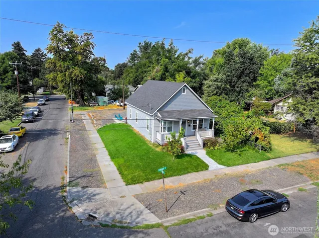a front view of a house with a yard and potted plants