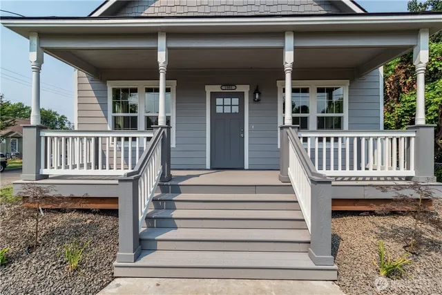 a view of a house with a deck and a floor to ceiling window