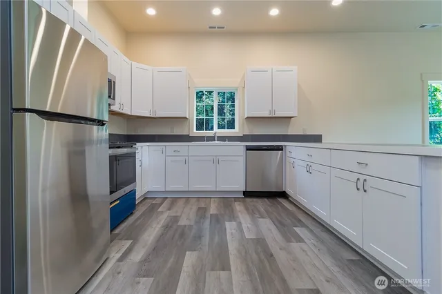 a kitchen with cabinets a sink and appliances