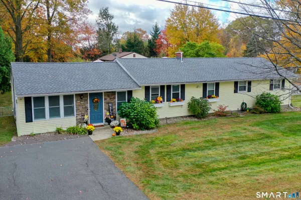 a front view of a house with a yard and outdoor seating