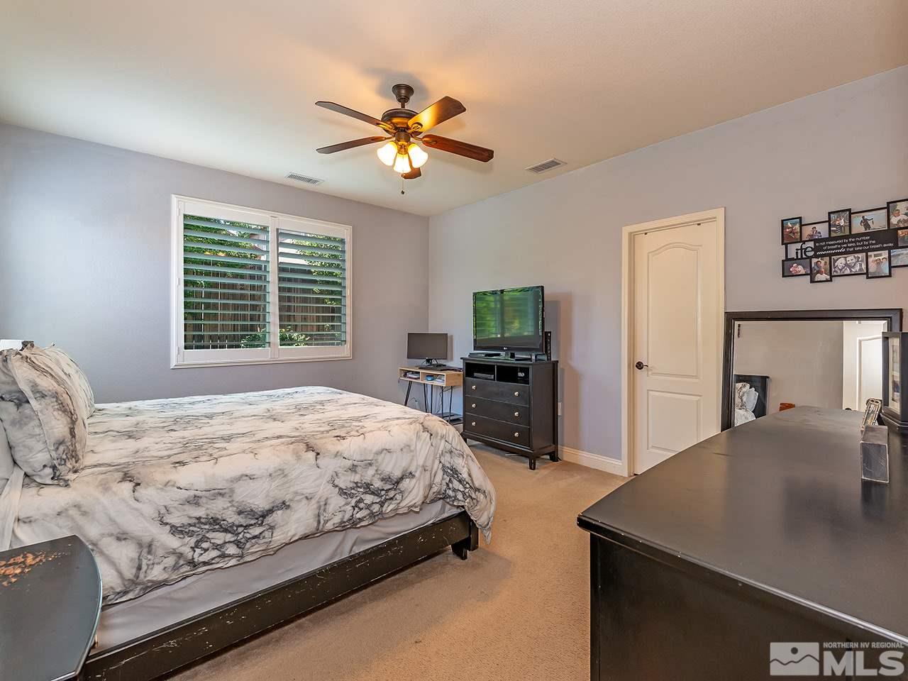 2150 Angel Ridge Drive Reno, NV 89521 - Photo 8 of 17 a bedroom with a bed and a chandelier