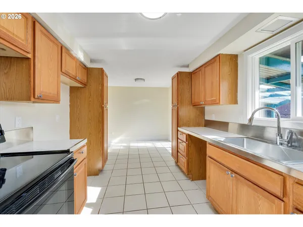 a kitchen with a sink a refrigerator and cabinets