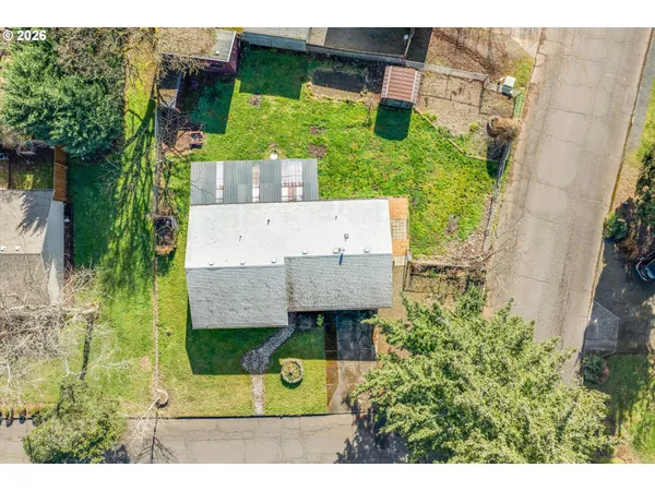 an aerial view of a house with a garden and large trees