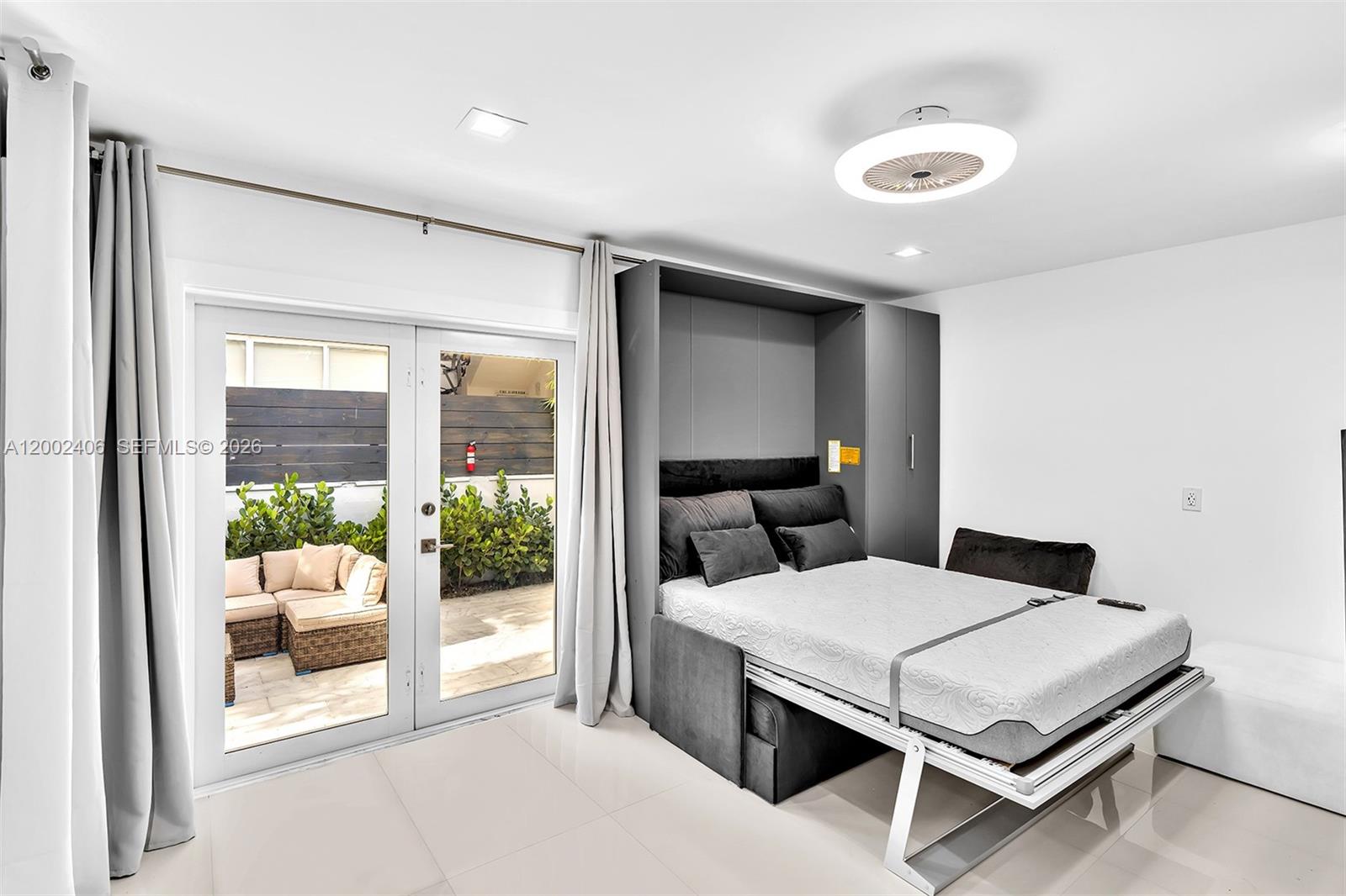 1002 10th Street, Unit 1002 Miami Beach, FL 33139 - Photo 18 of 71 a bedroom with a bed and glass door