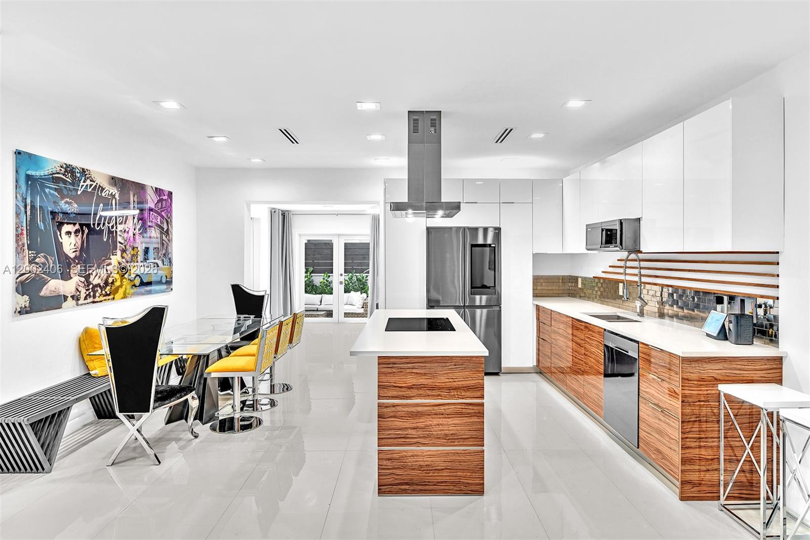 1002 10th Street, Unit 1002 Miami Beach, FL 33139 - Photo 8 of 71 a kitchen with stainless steel appliances kitchen island granite countertop a table chairs in it and wooden floors