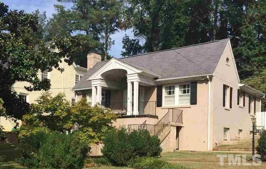 1418 Duplin Road Raleigh, NC 27607 - Photo 1 of 16 a view of a white house next to a yard with plants and trees