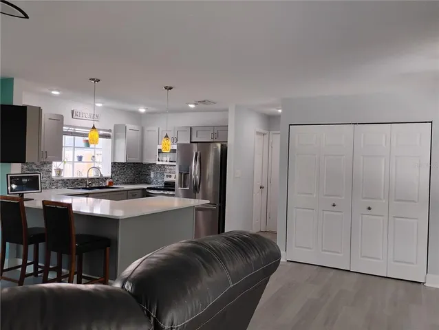 a kitchen with stainless steel appliances granite countertop a refrigerator and a stove top oven