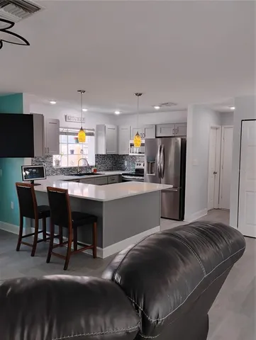 a kitchen with stainless steel appliances a refrigerator and a stove top oven