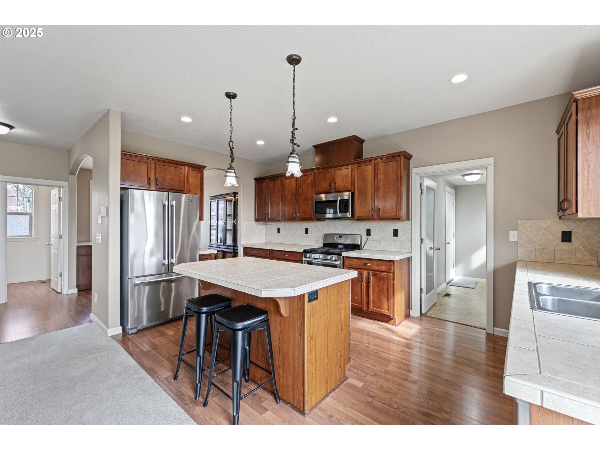 5462 Pranz Place Eugene, OR 97402 - Photo 12 of 43 a kitchen with stainless steel appliances kitchen island granite countertop a stove refrigerator and a sink