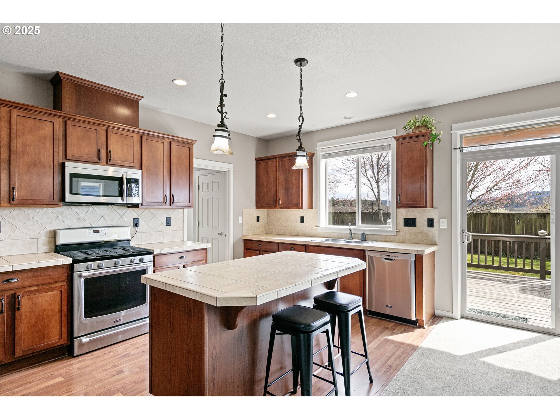5462 Pranz Place Eugene, OR 97402 - Photo 14 of 43 a kitchen with stainless steel appliances granite countertop a stove a sink a microwave a center island and a refrigerator