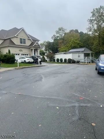 a front view of a house with a yard and car parked