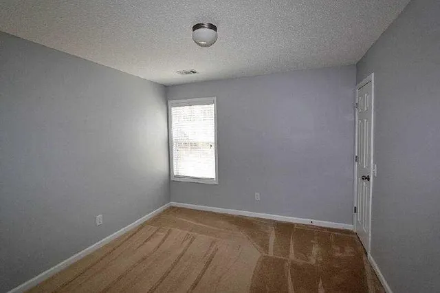 an empty room with a window and a ceiling fan