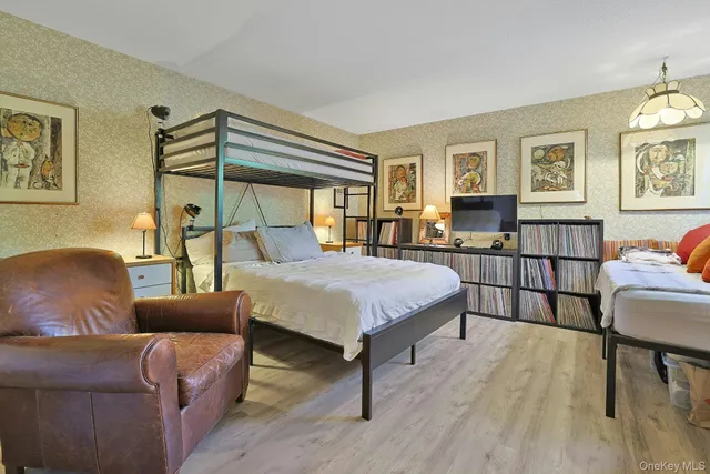 a bedroom with a bed wooden floor and windows