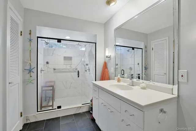 a bathroom with a shower sink and mirror