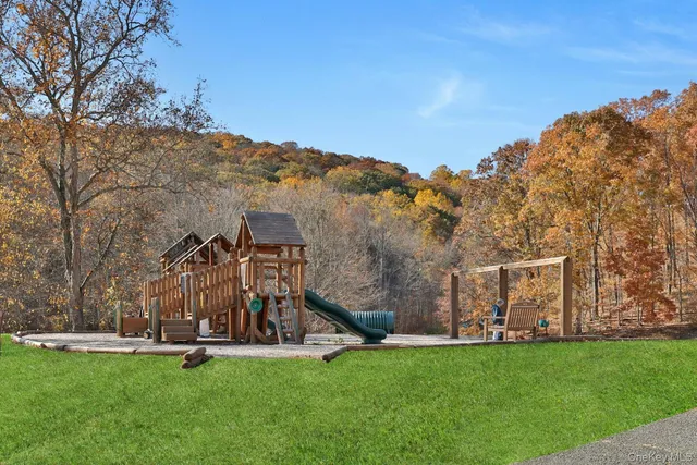 a view of an house with backyard and a tree