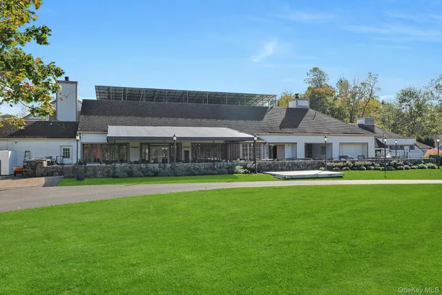 a front view of a house with swimming pool having outdoor seating