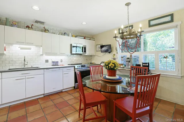 a kitchen with stainless steel appliances granite countertop a kitchen island a stove a table and chairs
