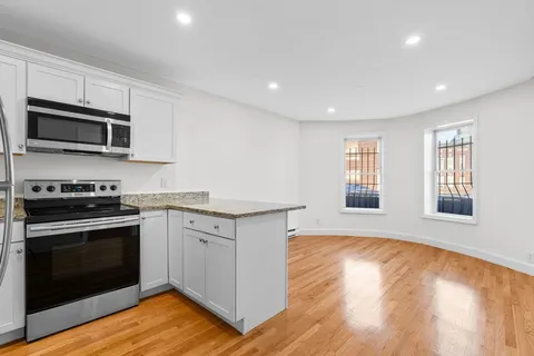 a kitchen with stainless steel appliances granite countertop a stove a sink and a microwave