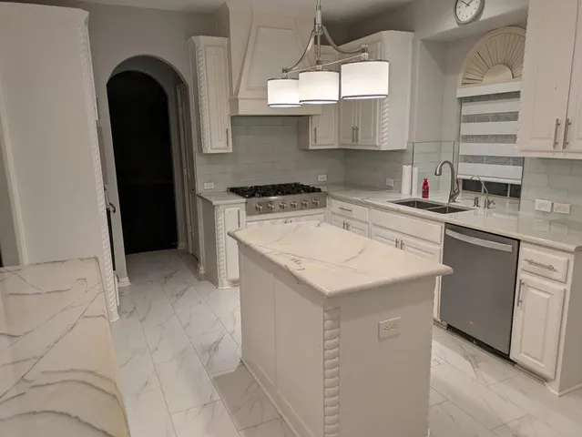 a kitchen with a sink a stove and cabinets