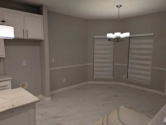 a view of a livingroom with wooden floor and a chandelier