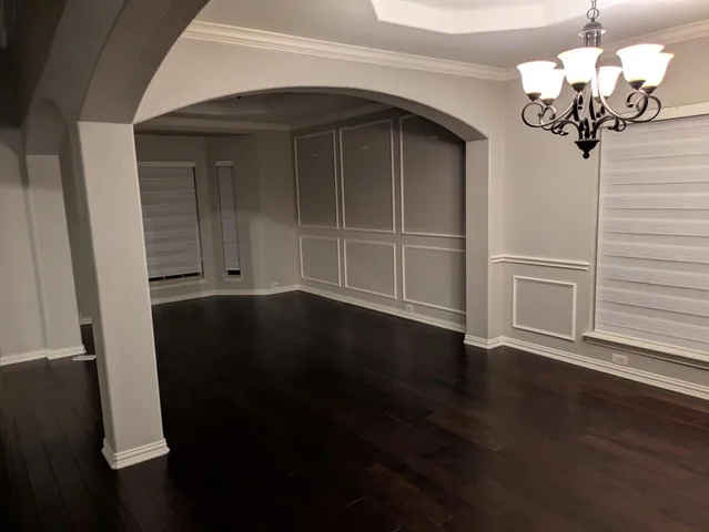an empty room with wooden floor closet and windows