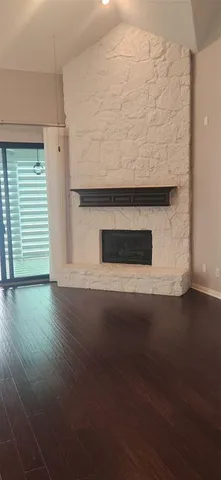 a living room with a wooden floor and a fireplace