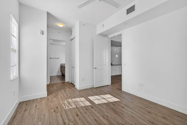 an empty room with wooden floor and a bathroom
