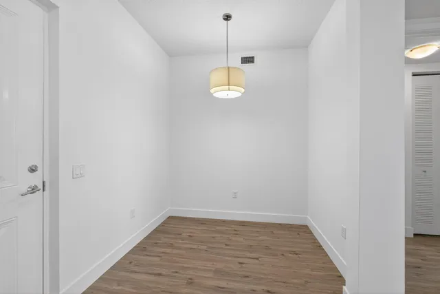 a view of a room with wooden floor and white walls