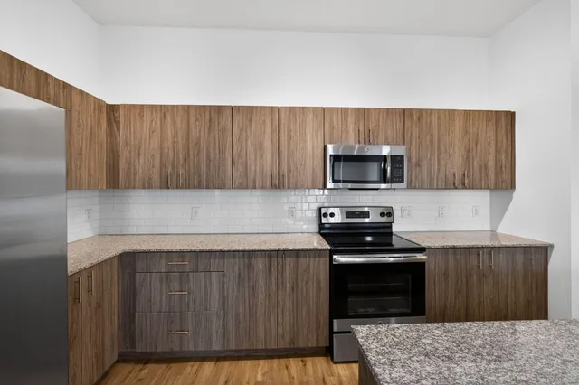 a kitchen with a stove a microwave and wooden cabinets