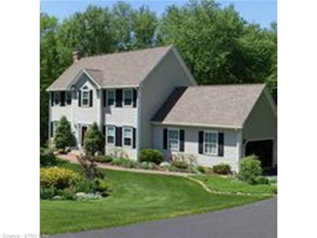 a aerial view of a house with a yard potted plants and a table chair