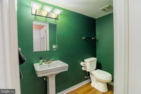 a bathroom with a sink toilet and a mirror