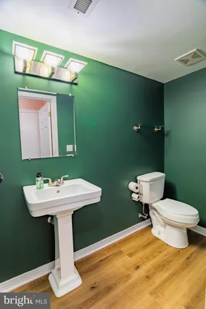 a bathroom with a toilet sink and mirror