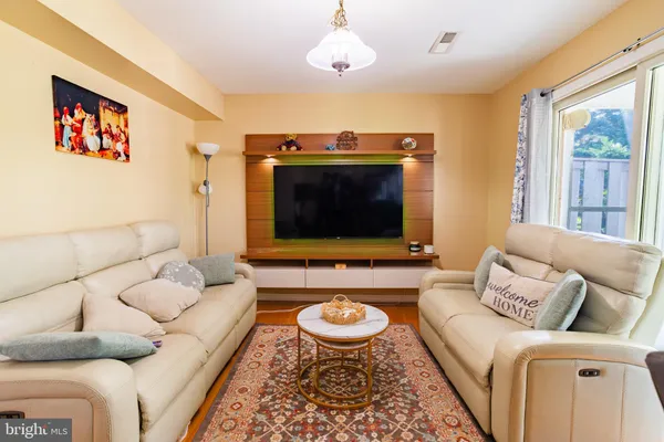a living room with furniture kitchen view and a large window
