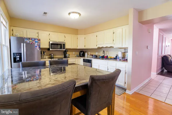 a kitchen with refrigerator a microwave a sink and cabinets
