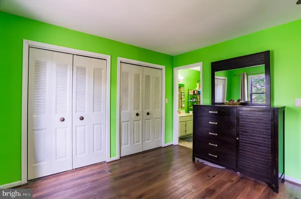 a view of a hallway with wooden floor and closet