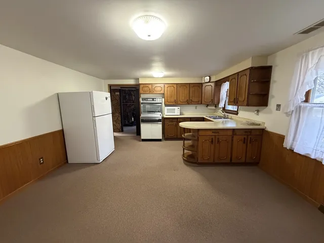 a kitchen with stainless steel appliances a refrigerator a sink a stove a microwave a counter top and oven