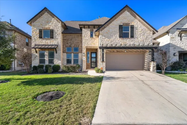 a front view of a house with a yard and garage