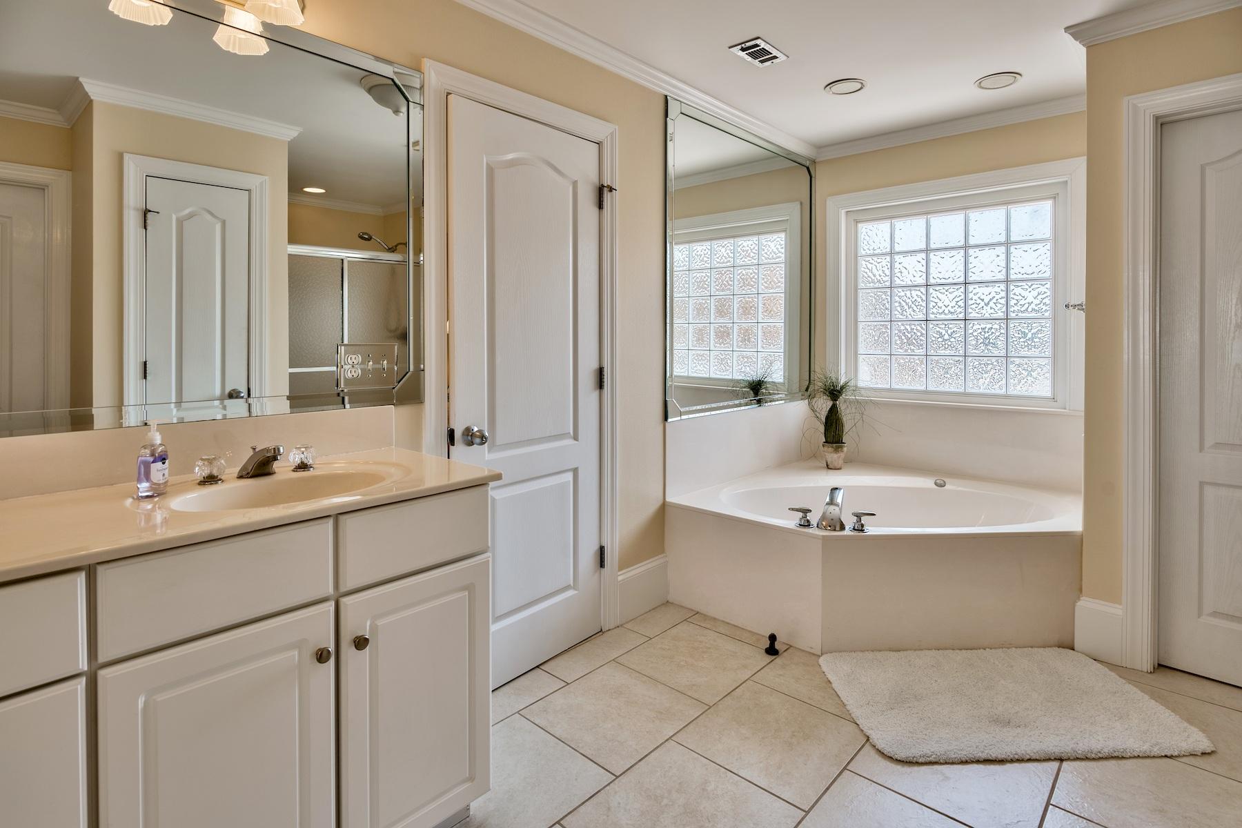 601 Blue Mountain Road Santa Rosa Beach, FL 32459 - Photo 26 of 51 a bathroom with a tub sink double vanity mirror and next to a window