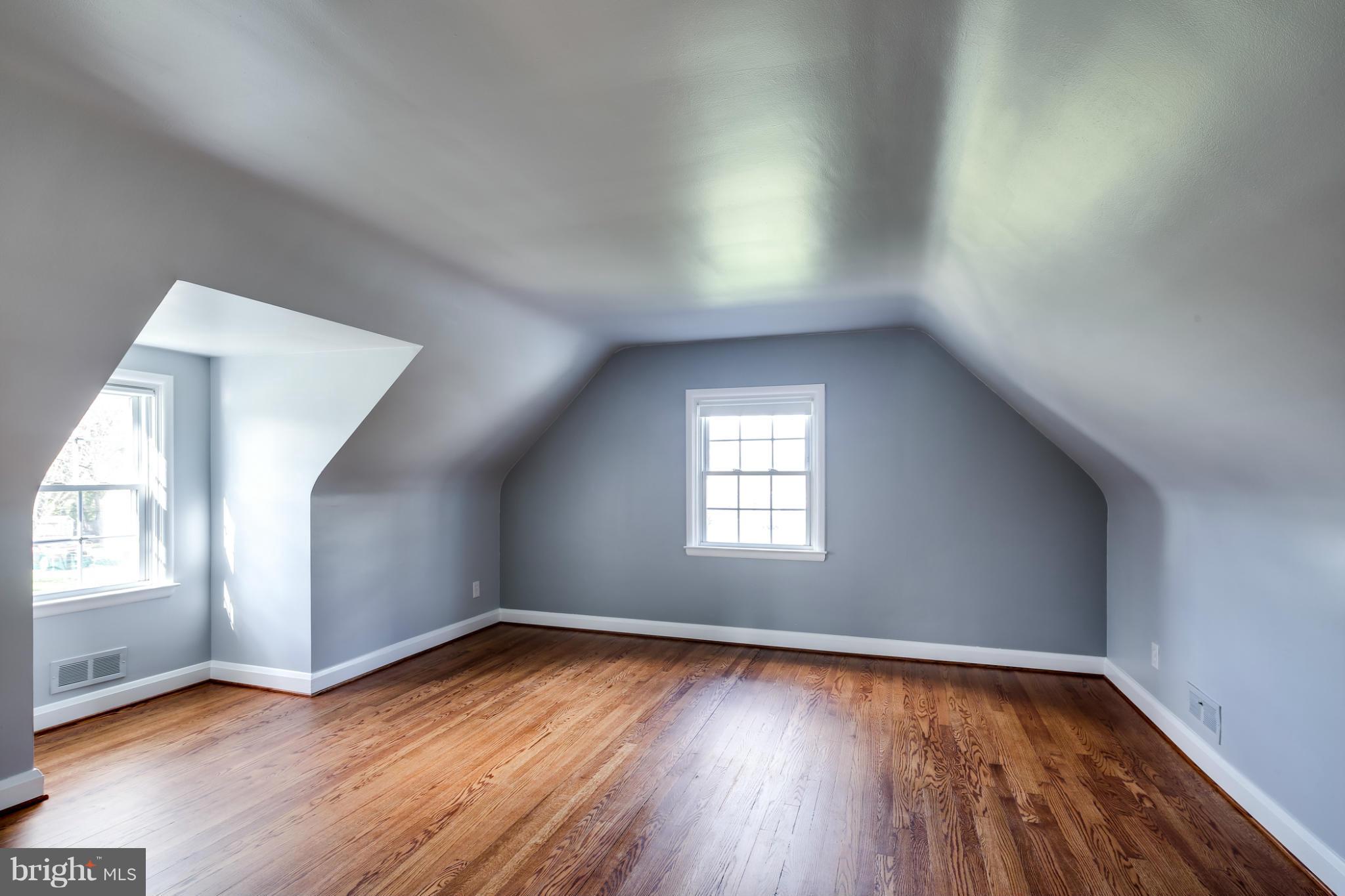 6704 Campfield Road Baltimore, MD 21207 - Photo 17 of 30 an empty room with wooden floor and windows