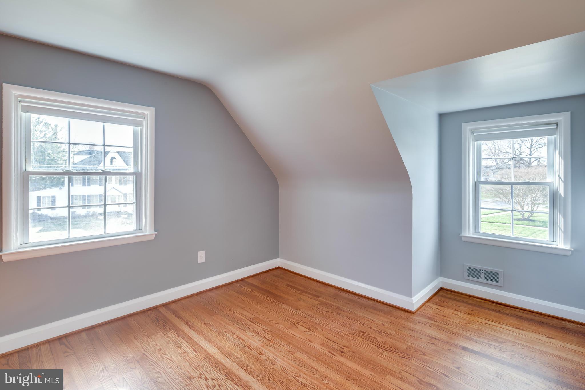 6704 Campfield Road Baltimore, MD 21207 - Photo 19 of 30 an empty room with wooden floor and windows