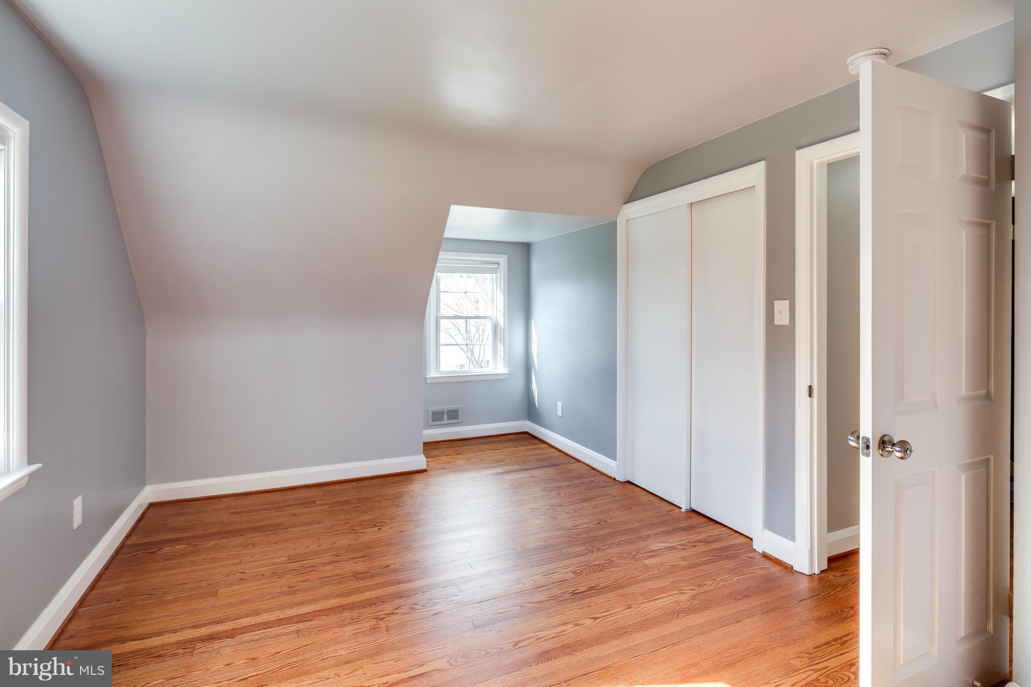 6704 Campfield Road Baltimore, MD 21207 - Photo 20 of 30 an empty room with wooden floor and windows