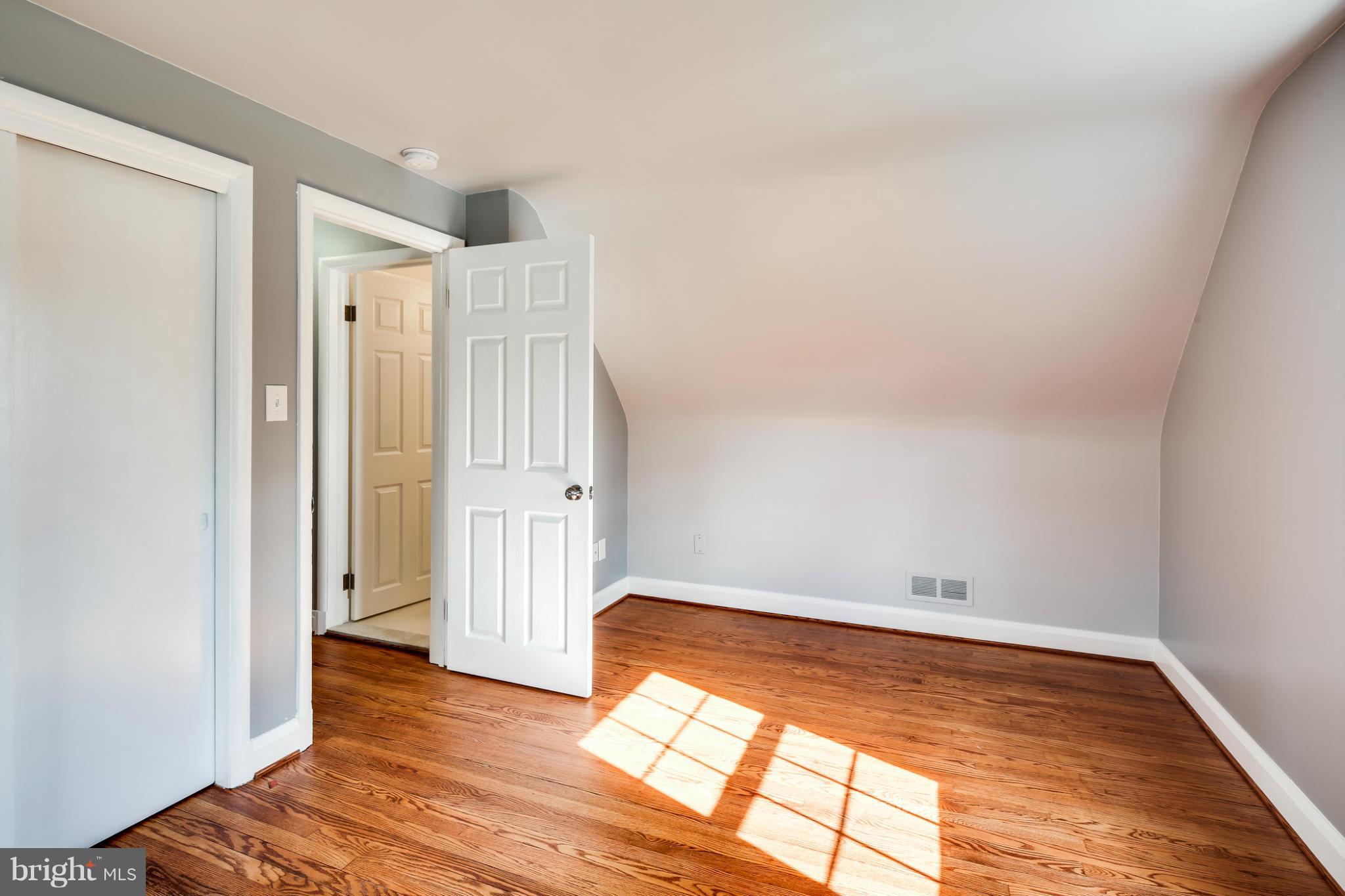 6704 Campfield Road Baltimore, MD 21207 - Photo 21 of 30 an empty room with wooden floor and windows