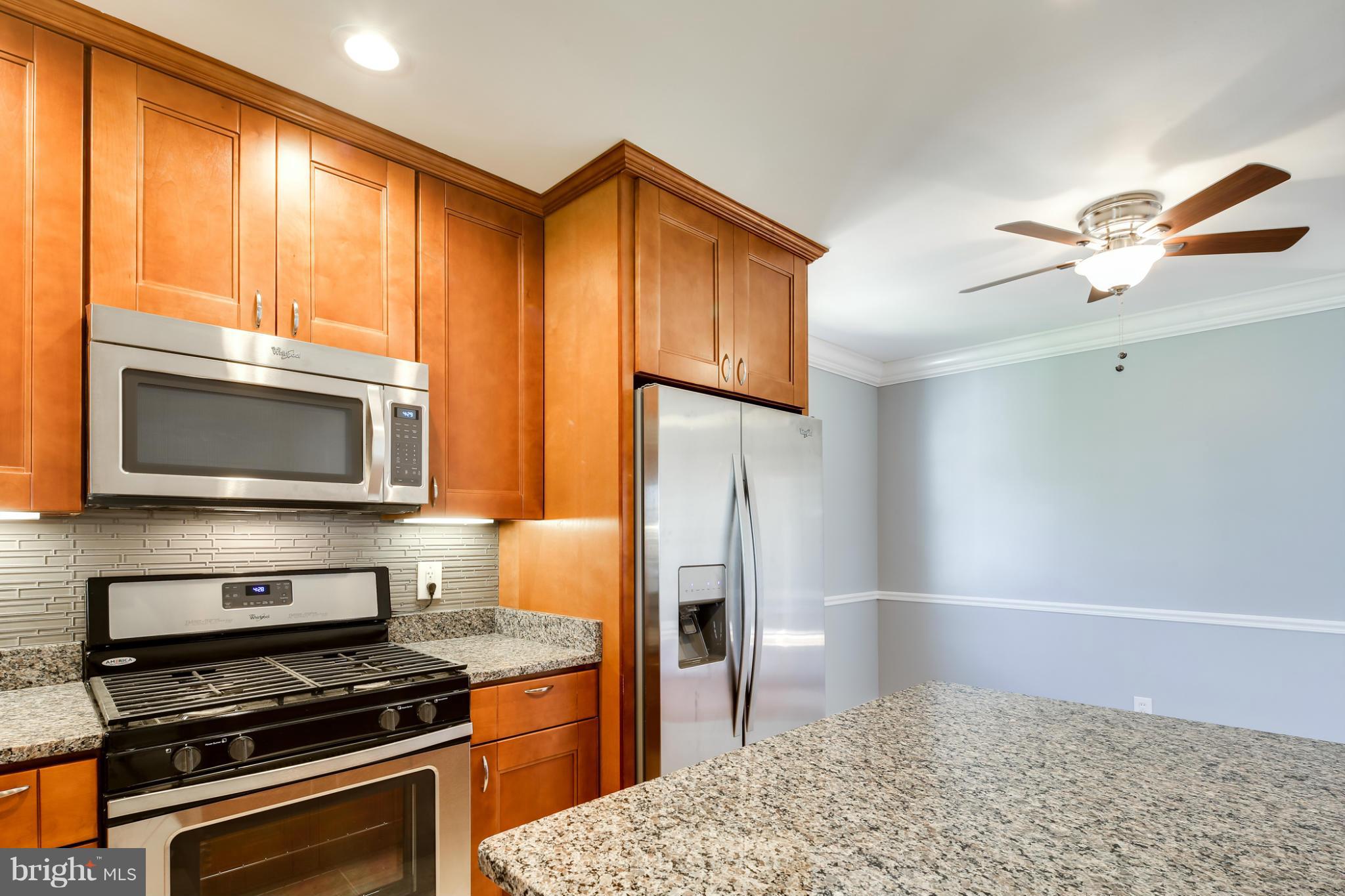 6704 Campfield Road Baltimore, MD 21207 - Photo 8 of 30 a kitchen with stainless steel appliances a stove a refrigerator and a sink