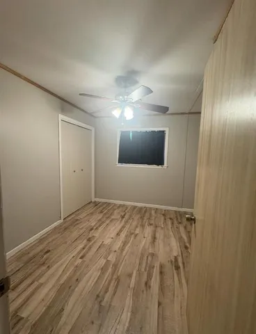 a view of an empty room and chandelier fan