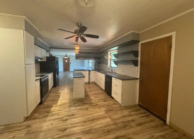a view of a kitchen with a sink and a refrigerator