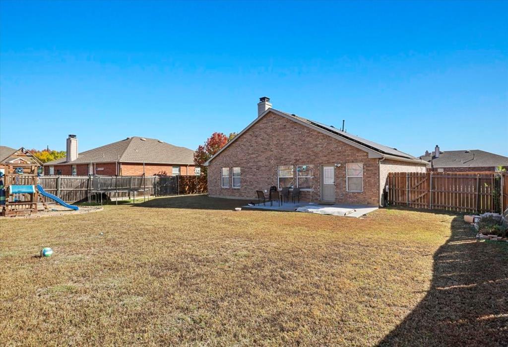 1412 Cheyenne Road Wylie, TX 75098 - Photo 24 of 24 Rear view of property featuring a patio, a playground, a fenced backyard, brick siding, and a chimney