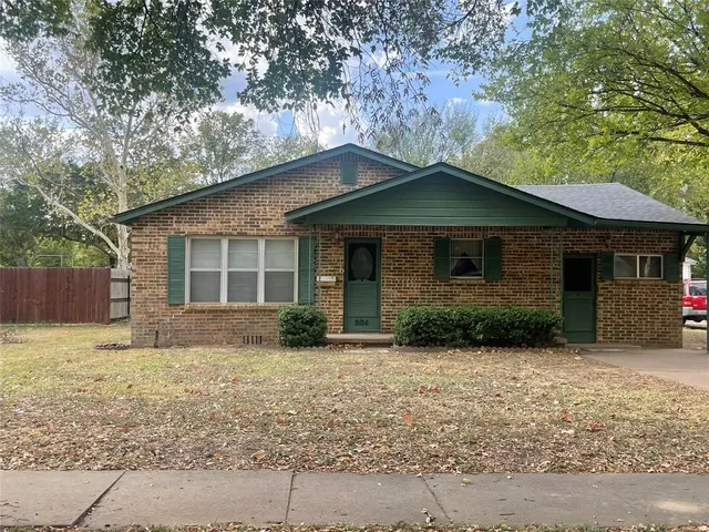 a front view of a house with a garden and yard