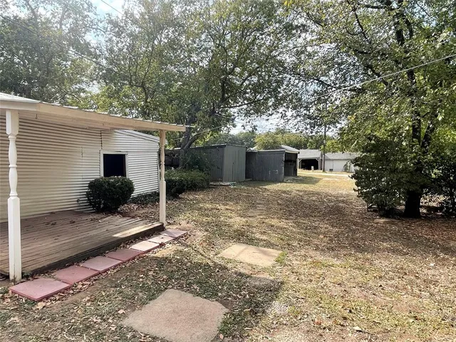a view of a house with backyard and trees