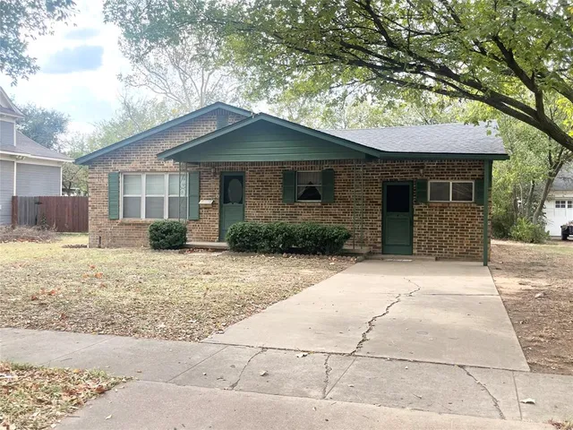 a front view of a house with a yard and potted plants
